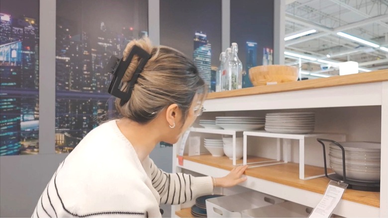Woman looking at IKEA plate and bowl collections in IKEA showroom