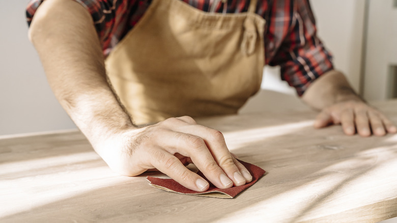 Person sanding a piece of wood