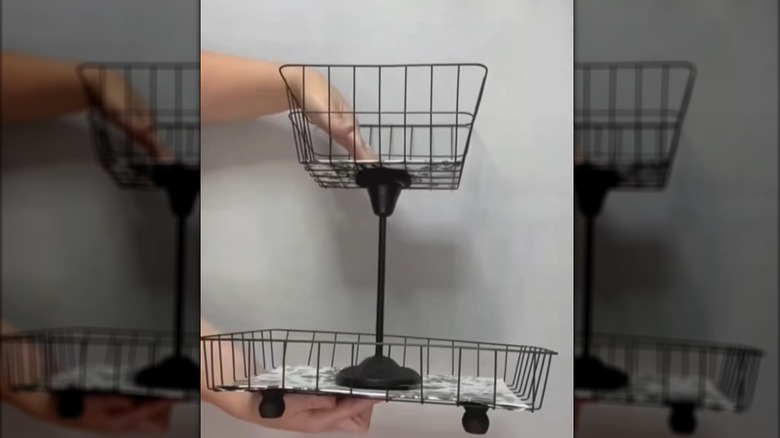 Creator holding a tiered wire basket organizer made from Dollar Tree items