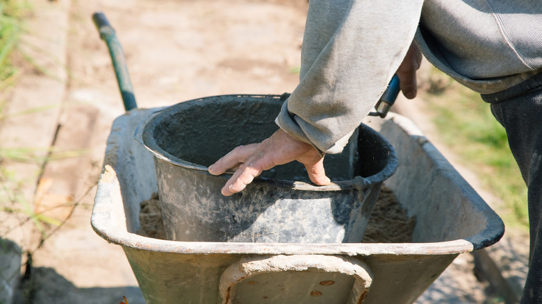 Person mixing cement for a pathway project
