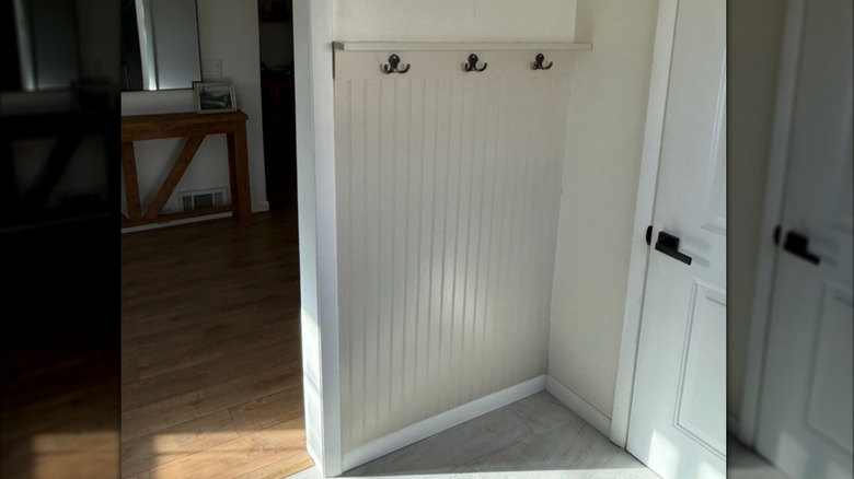 DIY entryway accent wall with coat hooks and a shelf