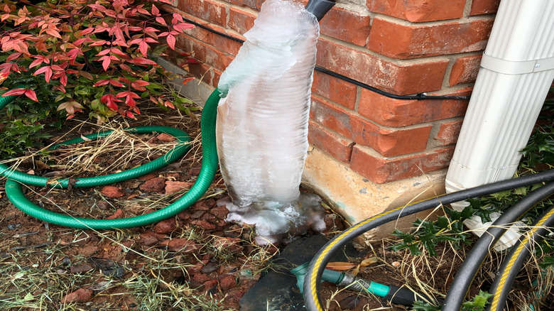 outdoor faucet and hose covered with ice
