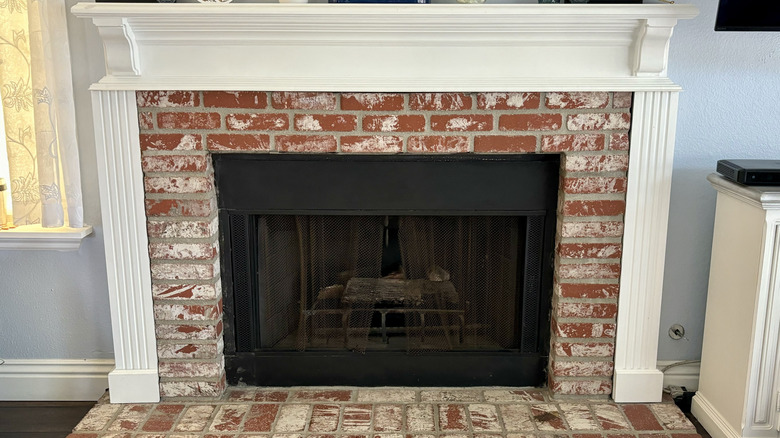 close up of fireplace with DIY brick hearth and white mantel