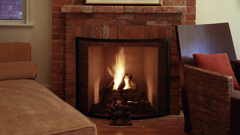 brick hearth fireplace with fire and lounge chairs