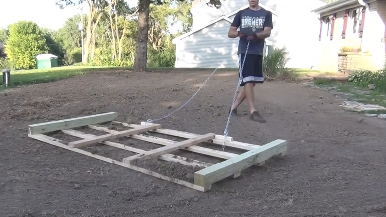 man pulling DIY lawn level