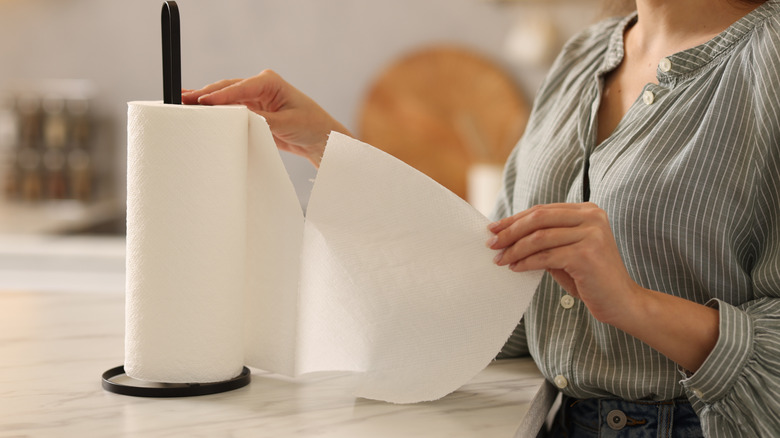 person ripping paper towel from roll
