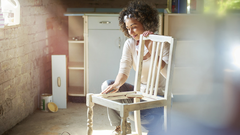 A woman takes apart an old chair
