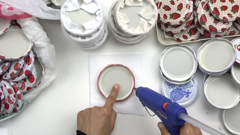 Woman using glue on an old jar lid