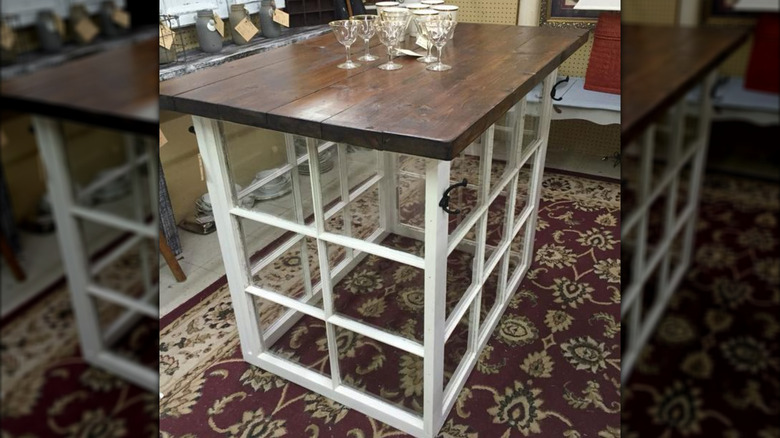 A kitchen island made from windows with glasses on top of it.