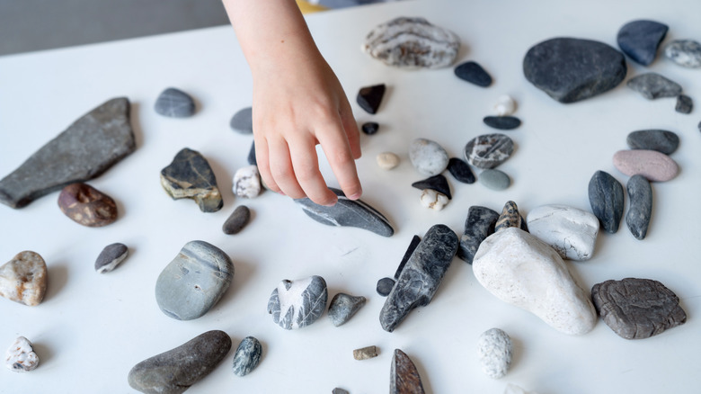 A person arranges stones on a table