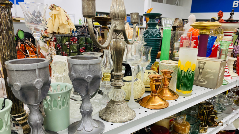 A selection of vintage candleholders and decor in a thrift store