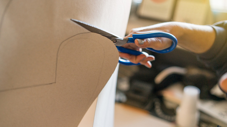 Person cutting a piece of cardboard