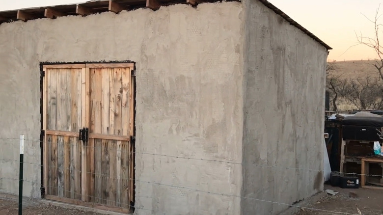 Large pallet-wood shed after first coat of stucco was applied