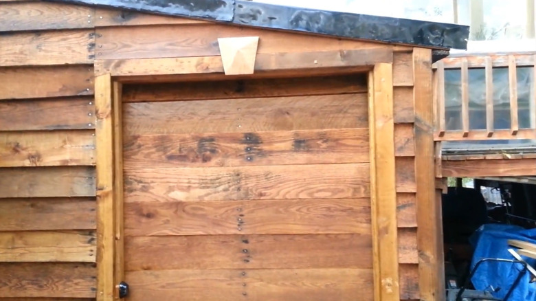 Small pallet-wood shed attached to garage
