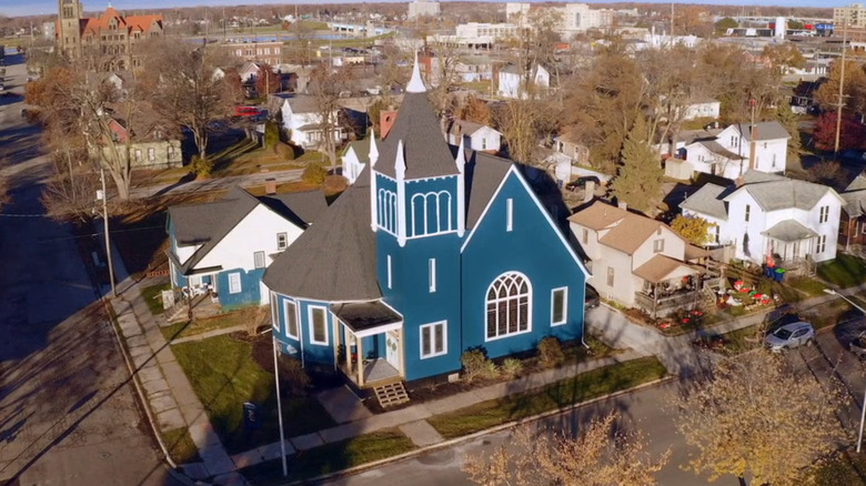 A bright blue church sits up in the background of a suburban neighborhood in this aerial photo
