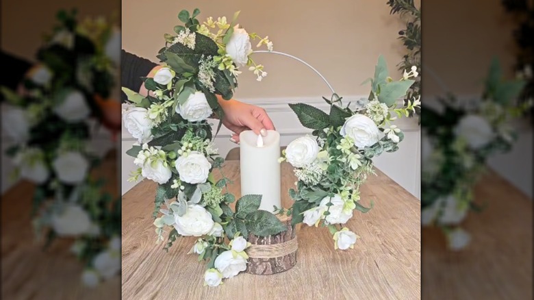 Pool noodle wire wreath with white floral arrangement on wood base with white pillar candle