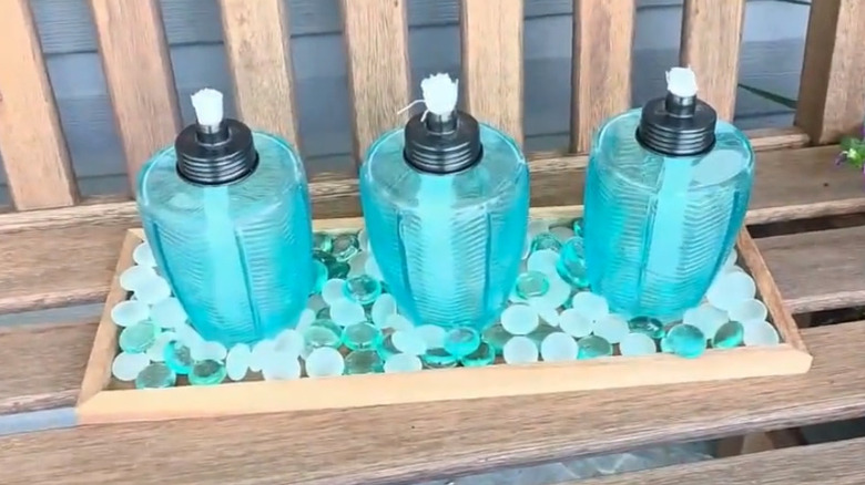 Wooden tray with Dollar Tree torches and glass gems on it