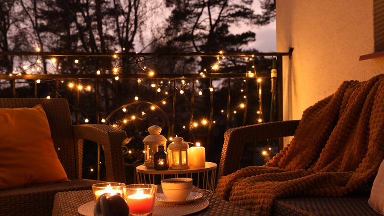 Balcony with patio furniture and lots of different types of lights