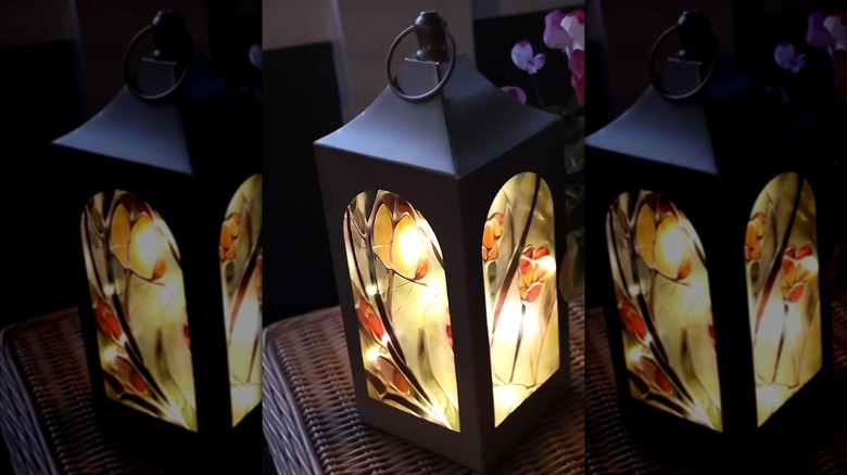 A small DIY stained glass porch light sits on a wicker table