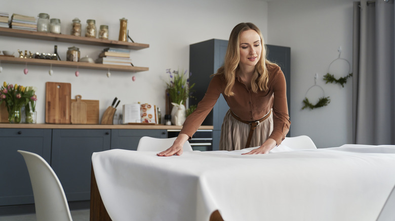 person decorating table with cloth