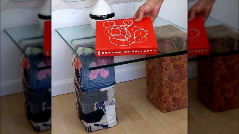Man placing book on top of DIY cinder block and glass end table