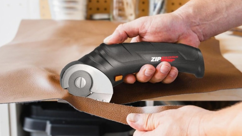Person using Worx Cordless Fabric & Cardboard Cutting Scissors to cut leather