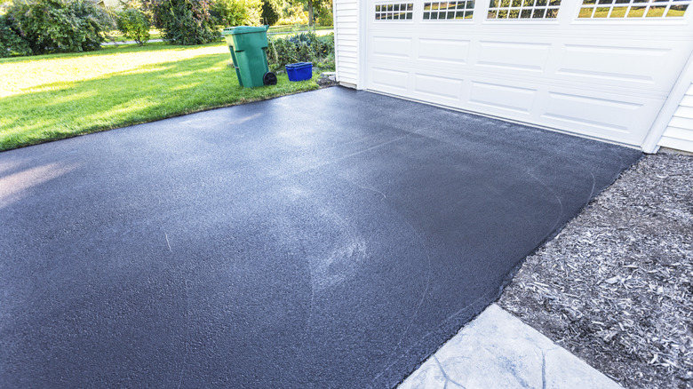 A fresh blacktop resealing job on an asphalt driveway