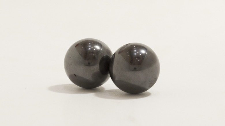 Two magnetic balls against a white background