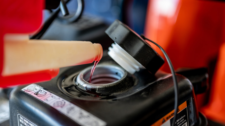 Fuel stabilizer is poured into a riding lawn mower gas tank