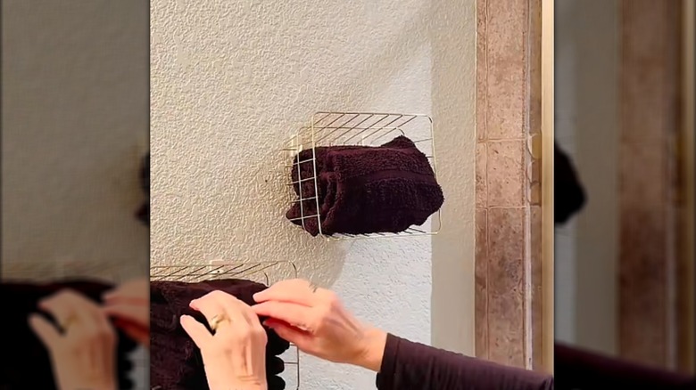 Dollar Tree wire baskets hanging on a wall with towels in them