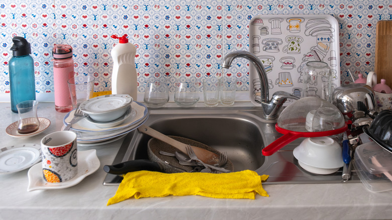 Kitchen sink with dirty dishes and clutter