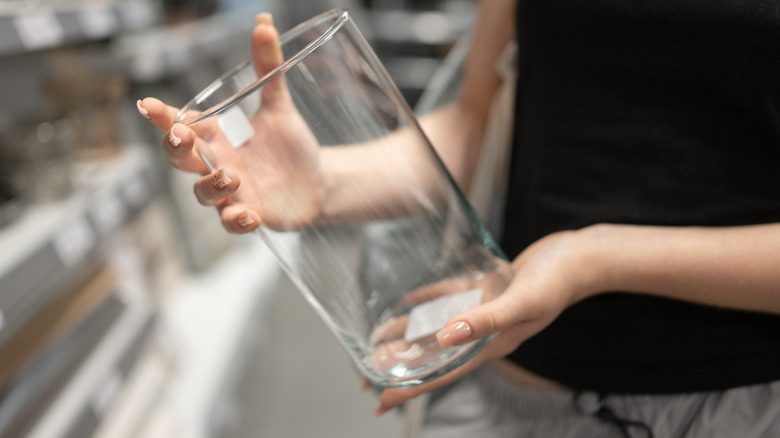 A woman holds a large tall glass