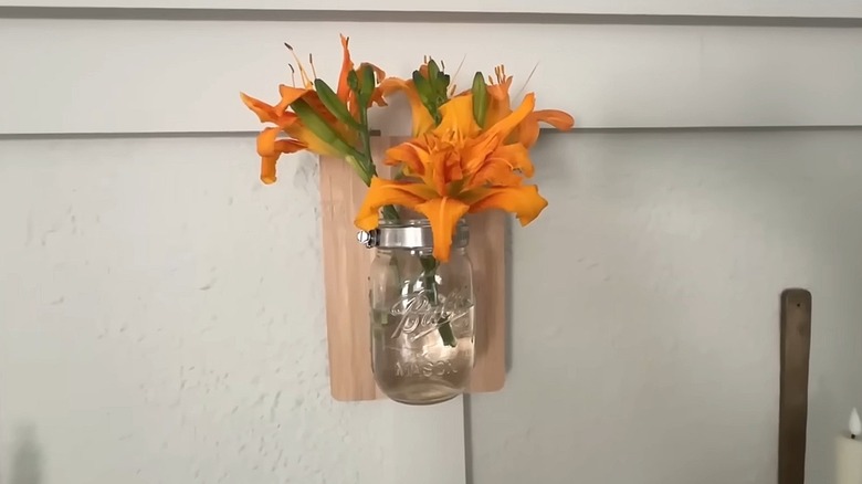 Floral display made by attaching a mason jar to a wooden cutting board
