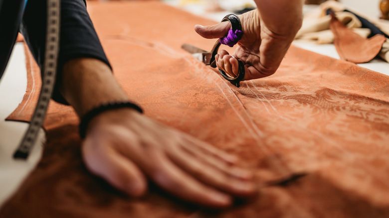 A cut cuts through fabric for reupholstery