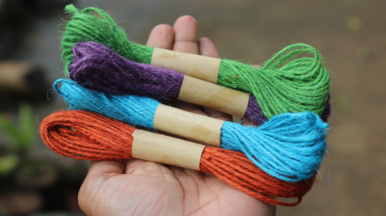 A hand holding colorful jute rope