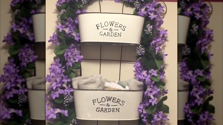 Shelf made with a trellis background and white metal baskets on front decorated with faux floral vines