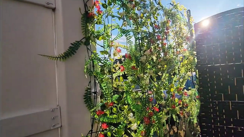 Dollar Tree trellises covered with faux vines and flowers to create a privacy screen