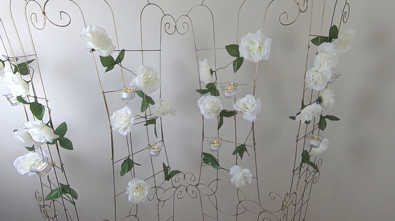 Freestanding rom divider with white floral garland and candle holders