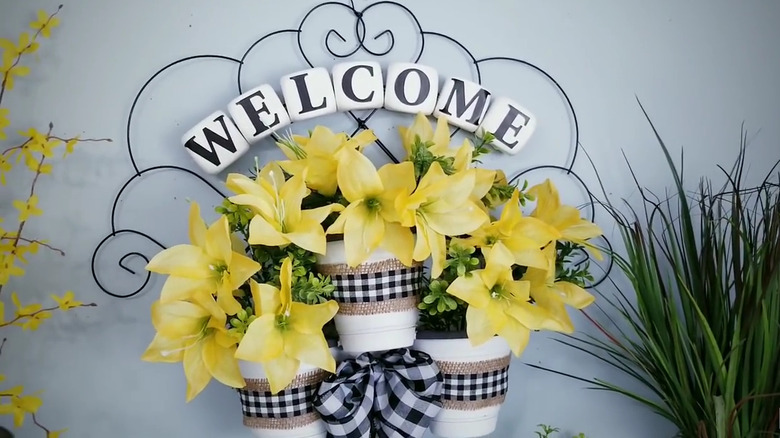 Welcome sign made from a trellis, pots, and faux flowers