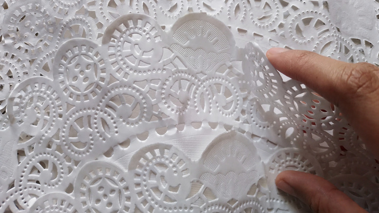 fingers grabbing paper doily