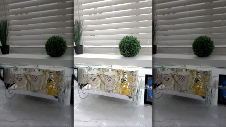 Shelf made of Dollar Tree paper towel holders and canvas prints displaying coffee mugs on it