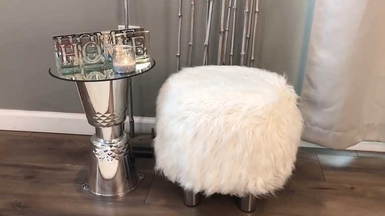 A fluffy white ottoman made out of pool noodles