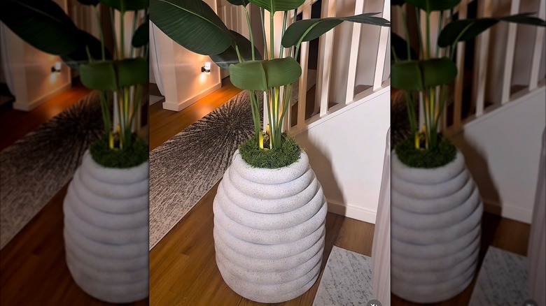 Large vase made of pool noodles with a potted plant inside