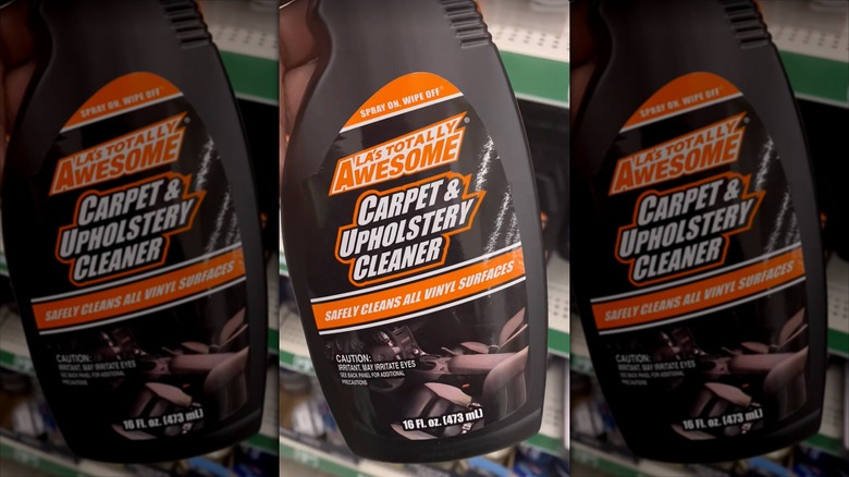 A person holds a bottle of LA's Totally Awesome Carpet & Upholstery Cleaner