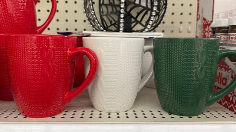 Selection of colorful seasonal mugs on a shelf at Dollar Tree
