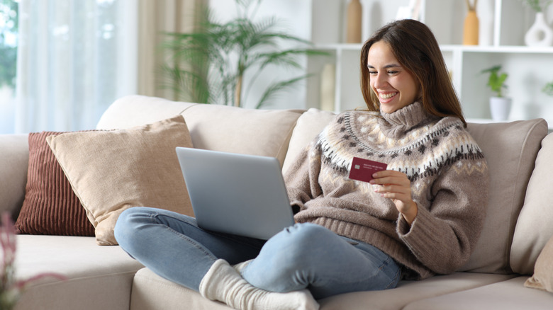 Woman with a cozy sweater shopping on a laptop