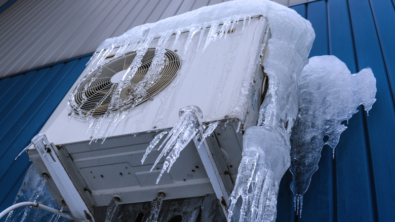 a split HVAC system's condenser unit covered in ice and snow