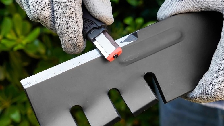 A man using the SHARPAL Blade sharpener to sharpen a blade