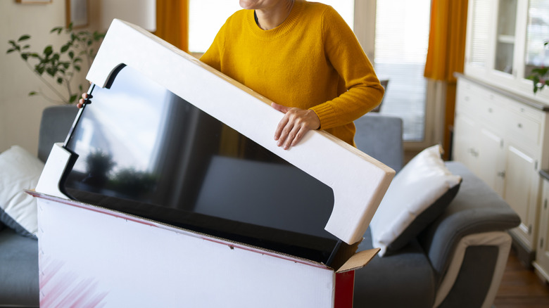 Woman putting in a TV in a large box