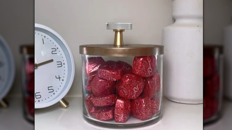 Glass jar candle turned into a storage container with candy inside